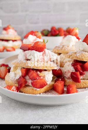 Sommerdessert mit Erdbeerkuchen. Traditionell gebacken mit kurzer Kruste, Schlagsahne und marinierten Erdbeeren Stockfoto