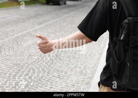 Ein Mann, der auf der Straße Auto fängt, Nahaufnahme. Anhalter-Tour Stockfoto