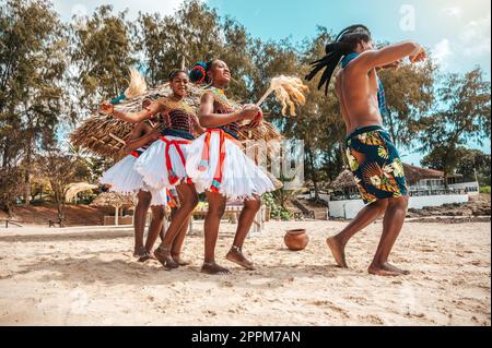 Kenianer tanzen am Strand mit typischen einheimischen Kleidern Stockfoto