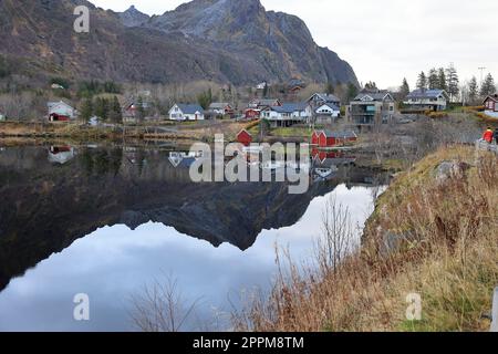 Reflexion eines kleinen Dorfes in einem See bei Svolvaer in Norwegen Stockfoto