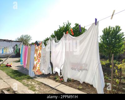 Sremska Mitrovica, Serbien 10. Juli 2020, Handtücher und Kleidung trocknen an einem Seil. Hausfrauen-Sorgen. Das feuchte Tuch wird zur weiteren Trocknung an Wäscheklammern aufgehängt. Große Wäsche Stockfoto