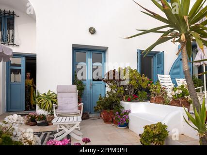 Blumen in Keramiktöpfen vor einem weiß getünchten Haus in Imerovigli auf der Insel Santorini Stockfoto