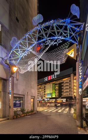 ikebukuro, japan - dezember 31 2019: Nachtansicht des beleuchteten Eingangstors der Sunshine Central Street, die den östlichen Ausgang von Ikebukuro verbindet Stockfoto