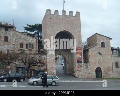 Assisi, Italien, 1. Dezember 2007 Antike Gebäude und Tore in der Stadt Assisi, Umbrien, Italien. Touristenattraktion. Touristen und die italienische Gendarmerie Stockfoto