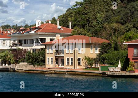 Grüne Berge auf der asiatischen Seite der Bosporus-Straße mit traditionellen Häusern und dichten Bäumen an einem Sommertag Stockfoto