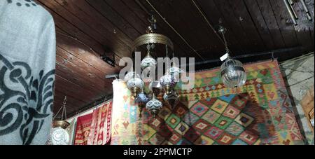 Traditionelle traditionelle türkische Lampen vor hellem Hintergrund in der Nacht. Farbige Glaslampen und -Schirme auf dem Markt in Sarajewo, Bosnien und Herzegowina. Verkauf von Souvenirs auf dem Markt. Stockfoto