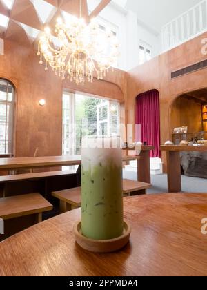 Eismatcha Greentea auf Holztisch im Café Stockfoto