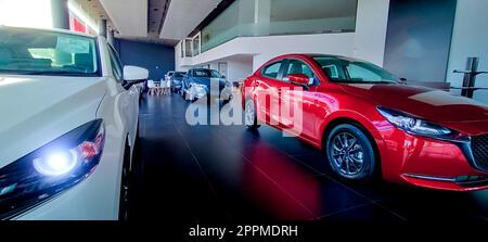 Auto parkt in einem luxuriösen Ausstellungsraum. Büro des Autohändlers. Neues rotes Auto im modernen Ausstellungsraum. Geschäftskonzept Auto zum Verkauf und zur Miete. Kfz-Leasing- und Versicherungskonzept. Autohändler. Stockfoto