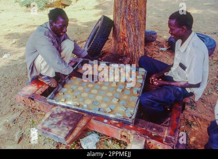 Senegal, Bambay, Männer spielen Dame unter einem Baum. Stockfoto