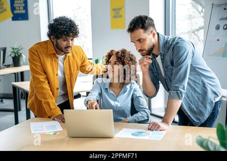 Teamarbeit, Zusammenarbeit. Erfolgreiche Menschen unterschiedlicher Nationalitäten, kreatives Business-Team, Zusammenarbeit an einem Projekt in einem modernen Büro, Zuschauen von Präsentationen, Diskussionen über Ideen, Brainstorming Stockfoto