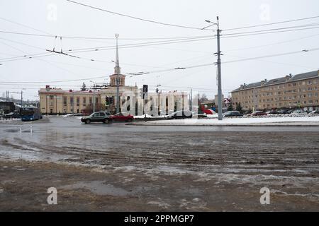 Petrozavodsk, Republik Karelien, Russland, 16. Januar 2023. Gagarin Square, Lenin Avenue. Das tägliche Leben der Russen. Öffentliche Verkehrsmittel und Autos fahren. Bahnhof. Schnee, Schneeverwehungen und Matsch. Stockfoto