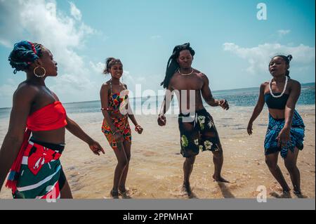 Kenianer tanzen am Strand mit typischen einheimischen Kleidern Stockfoto