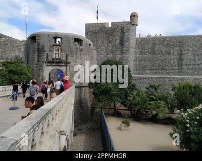 Pile Gate Dubrovnik Kroatien August 14 2022 Menschen Männer und Frauen gehen entlang der Steinbrücke zum Tor der Altstadt. Eine Menge Touristen. Geschäftiger Eingang. Haupteingang Altstadt, geschäftiges Pile Gate Stockfoto