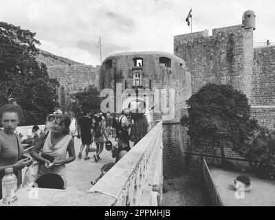 Pile Gate Dubrovnik Kroatien August 14 2022 Menschen Männer und Frauen gehen entlang der Steinbrücke zum Tor der Altstadt. Eine Menge Touristen. Geschäftiger Eingang. Haupteingang Altstadt, geschäftiges Pile Gate Stockfoto