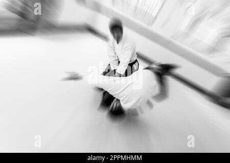 Menschen üben Aikido in einem Dojo-Hintergrund. Stockfoto