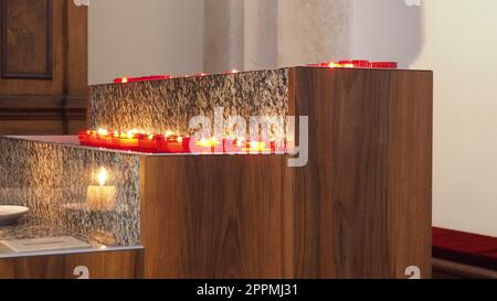 Memorial Day mit Kerze. Gedenkkerzen sind angezündet. Auf dem Friedhof brennen Kerzenflammen. Brennende Kerzen in der katholischen Kirche in Dubrovnik, Kroatien. Viele Kerzen. Die Flamme schwankt im Zug Stockfoto