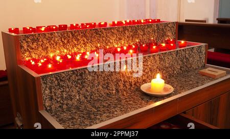 Memorial Day mit Kerze. Gedenkkerzen sind angezündet. Auf dem Friedhof brennen Kerzenflammen. Brennende Kerzen in der katholischen Kirche in Dubrovnik, Kroatien. Viele Kerzen. Die Flamme schwankt im Zug Stockfoto