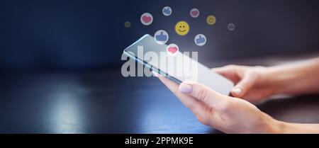 Frauenhände halten Handy auf schwarzem Hintergrund. Stockfoto