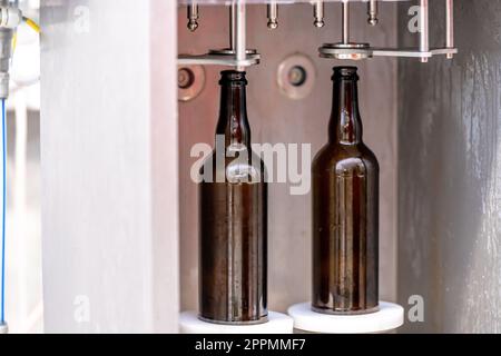 Maschine zum Waschen und Befüllen von Glasflaschen mit Bier Stockfoto