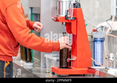 Bierflaschen auf einer Maschine in einer Brauerei verschließen Stockfoto