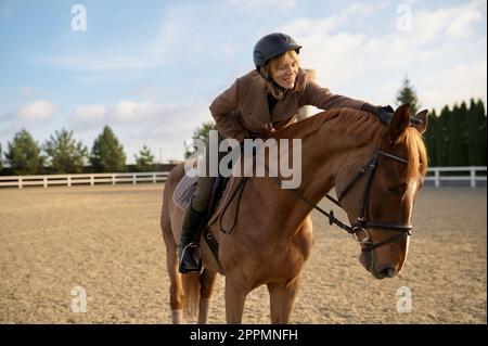 Eine Pferdetrainerin mit ihrem Hengst draußen auf der Farm Stockfoto