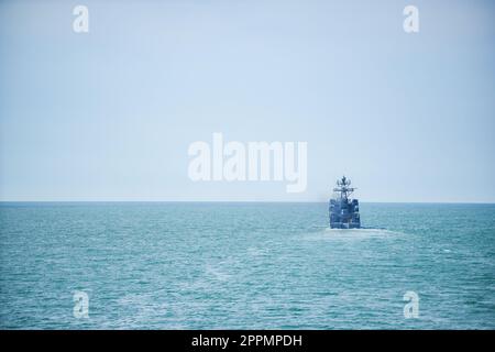 Kriegsschiff in stillem Wasser Segeln Stockfoto