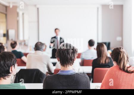 Sprecher hält einen Vortrag bei einem Geschäftstreffen. Publikum im Konferenzsaal. Wirtschaft und Unternehmertum. Kopieren Sie den Bereich auf das Whiteboard Stockfoto