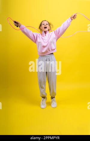 Bezauberndes weibliches Kind mit Seilspringen im Studio Stockfoto