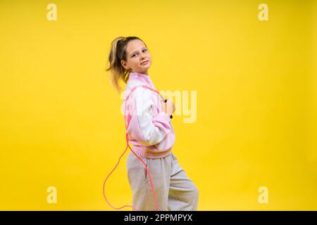 Bezauberndes weibliches Kind mit Seilspringen im Studio Stockfoto