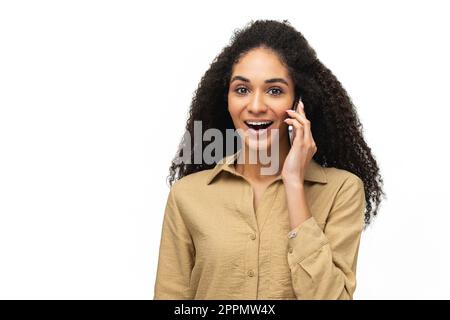 Junge, positive, afroamerikanische Frau, die telefoniert, telefoniert, ein Gespräch führt, isoliert auf weiß steht, Werbekonzept Stockfoto