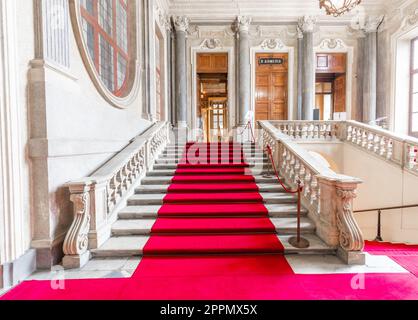 Turin, Italien - ca. Januar 2022: Roter Teppich im Königspalast - luxuriöse elegante Marmortreppe. Stockfoto
