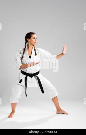 Frau in voller Länge mit schwarzem Gürtel Kimono üben Karate Stockfoto