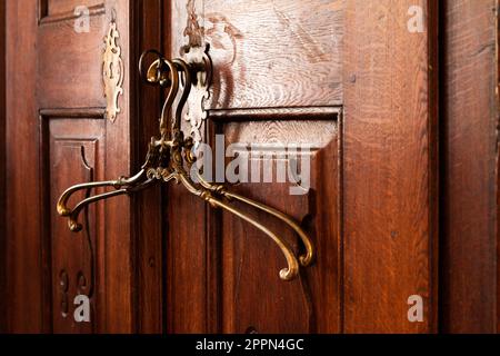 10.08.2021 Miclosoara Rumänien. Klassische kleiderbügel aus französischem Messing. Alter Schrank aus massivem Holz. Stockfoto