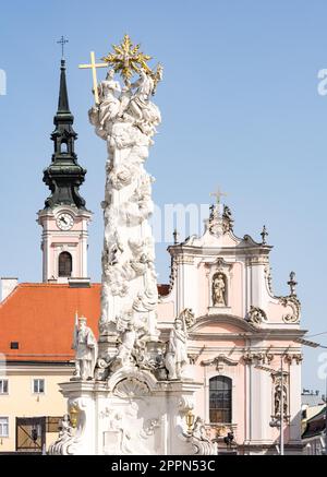 Die Säule der Heiligen Dreifaltigkeit (erbaut im 18. Jahrhundert) und die Franziskanerkirche auf dem Rathausplatz in Sankt Poelten Österreich Stockfoto
