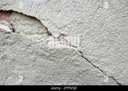Großer, langgewickelter, absteigender Riss an alter grüner Putzwand. Speicherplatz kopieren. Selektiver Fokus. Stockfoto