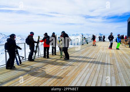 Les Ménuires, Frankreich - 16. März 2023 : Skifahrer und Touristen genießen den Blick über die französischen Alpen von einer Promenade auf der Spitze von La Masse Mo Stockfoto