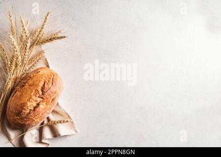 Frisches hausgemachtes Sauerteigbrot. Brot mit Weizenohren auf weißem Hintergrund, Kopierbereich. Stockfoto