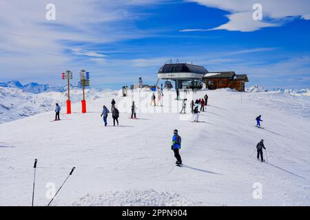 Skifahrer verlassen im Winter die Sessellift-Station Roc 2 an der Spitze der Pisten im Skigebiet Les Ménuires in den französischen Alpen Stockfoto