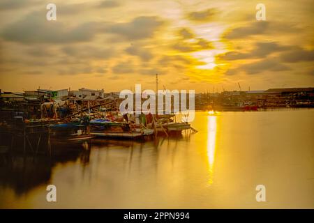 Fischerdorf in Kamal, Jakarta, Indonesien, mit festgefahrenen Booten. Bewegungsunschärfe bei sich bewegenden Booten. Langzeitbelichtung. Stockfoto