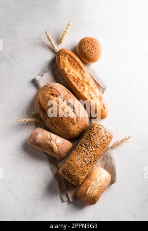 Auswahl an leckerem, frisch gebackenem Brot. Auswahl an handwerklich hergestelltem Brot und Weizenohren. Stockfoto