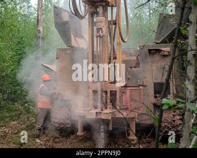 Das Raupenbohrgerät bohrt gut, viel Staub beim Bohren von Bohrlöchern. Stockfoto