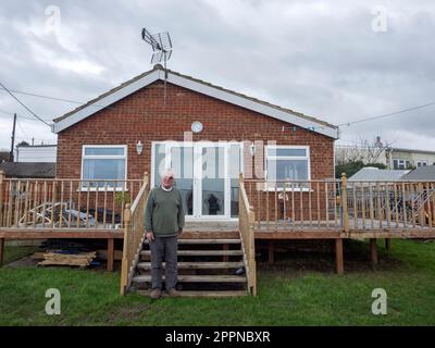 Eastchurch, Kent, Großbritannien. 24. April 2023. [PIC von Mr. Cane vor seinem Grundstück in 2021 EINREICHEN] der Besitzer des Cliff-Edge-Hauses Edd Cane hat den extremen Schritt unternommen, Bagger zu engagieren, die versuchen, sein Haus an der Klippe in Eastchurch, Kent, Aber es gab Probleme mit dem Swale-Rat und der Umweltagentur aufgrund angeblicher Kontaminationsprobleme. Die Bilder zeigen Erdbewegungspflanzen neben seinem Grundstück an der Ecke Dawn Rise/Third Ave. Kredit: James Bell/Alamy Live News Stockfoto