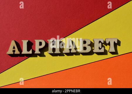 Alphabet, Wort in hölzernen Buchstaben isoliert auf farbenfrohem Hintergrund Stockfoto