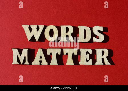 Wörter sind wichtig, in hölzernen Buchstaben isoliert auf rotem Hintergrund Stockfoto