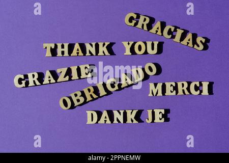 Danke, Wort in Englisch und verschiedenen europäischen Sprachen, isoliert auf lila Hintergrund Stockfoto