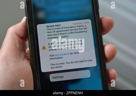 Handy in der Hand mit Bildschirm zeigt Text von Test für schweren Alarm, Dies ist ein Test von Notfallwarnungen, ein neuer Regierungsdienst Stockfoto