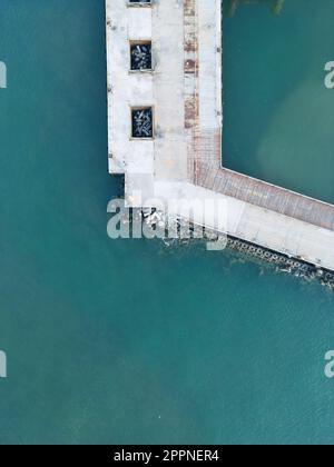 Ein Luftblick auf einen Betonpier, der sich über das Meer erstreckt Stockfoto