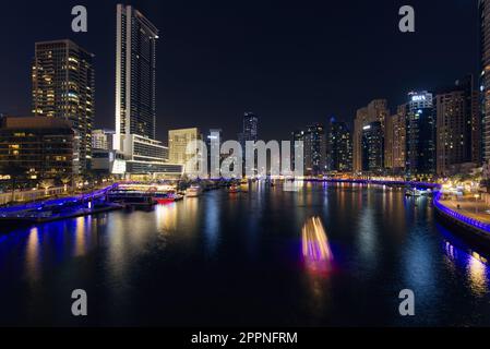 Dubai, Vereinigte Arabische Emirate - 04. Februar 2023: Dubai Marina Skyline Panoramablick bei Nacht. Gebäude sind beleuchtet, Wasser reflektiert Licht. Yachten am Pier. Ansicht von Stockfoto