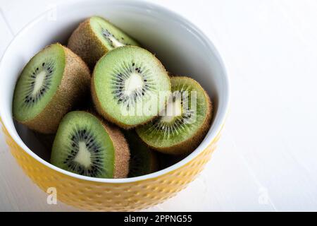 Kiwis auf weißem Holzhintergrund mit Kopierbereich. Stockfoto