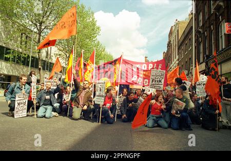 Protest am Mai 1998, Demonstranten und Demonstranten sitzen in der Theobalds Road Holborn mit anti-kapitalistischen Plakaten und Bannern Stockfoto